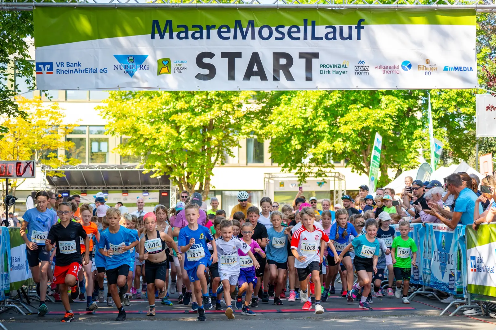 Start des Kinderlaufs beim Maare-Mosel-Lauf, über der Startlinie hängt ein Banner mit dem Logo der Nürburg Quelle